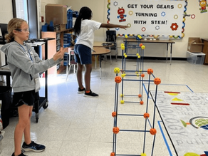 Two students in a STEM classroom building with engineering kits, practicing teamwork and problem-solving in an enrichment program.