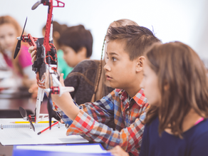 Students collaborate on a classroom drone project, examining its structure and components while applying STEM concepts in a hands-on science learning activity.