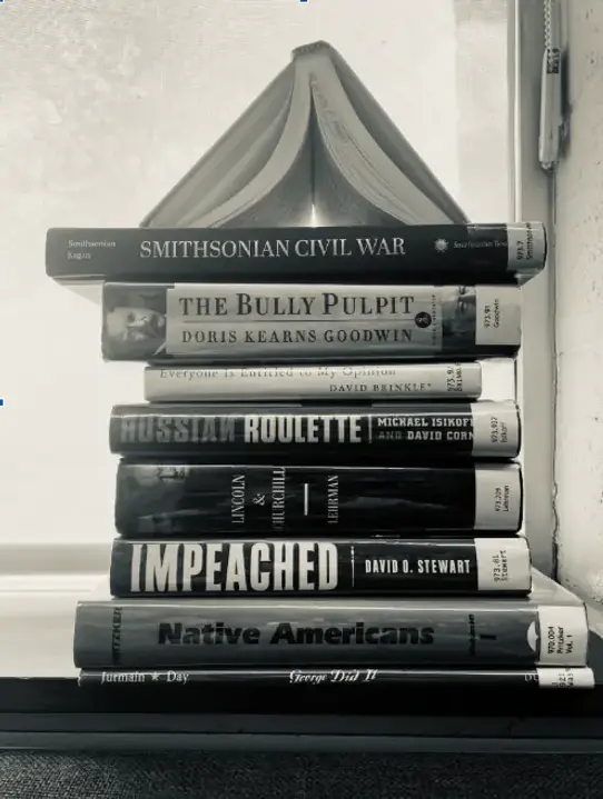 A stack of eight books that are titled, from top to bottom: Smithsonian Civil War, The Bully Pulpit, Everyone is Entitled to My Opinion, Russian Roulette, Lincoln & Churchill, Impeached, Native Americans, George Did It.