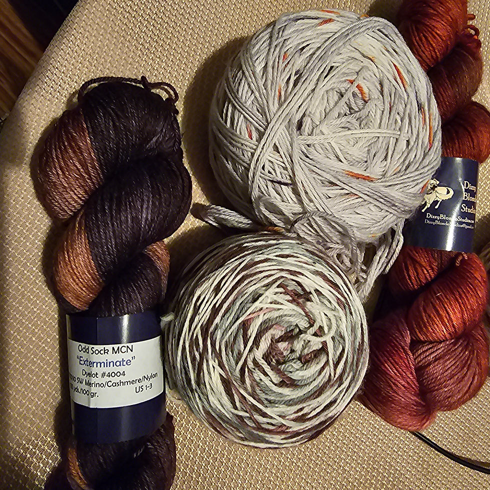Yarn in the colors of grey, brown, gold, and auburn.