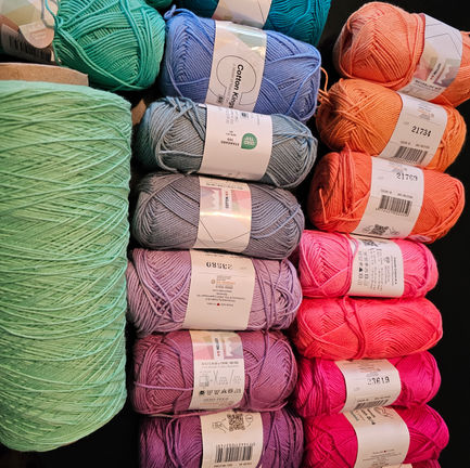 A set of colorful yarn in a gradient between orange and light blue-green.