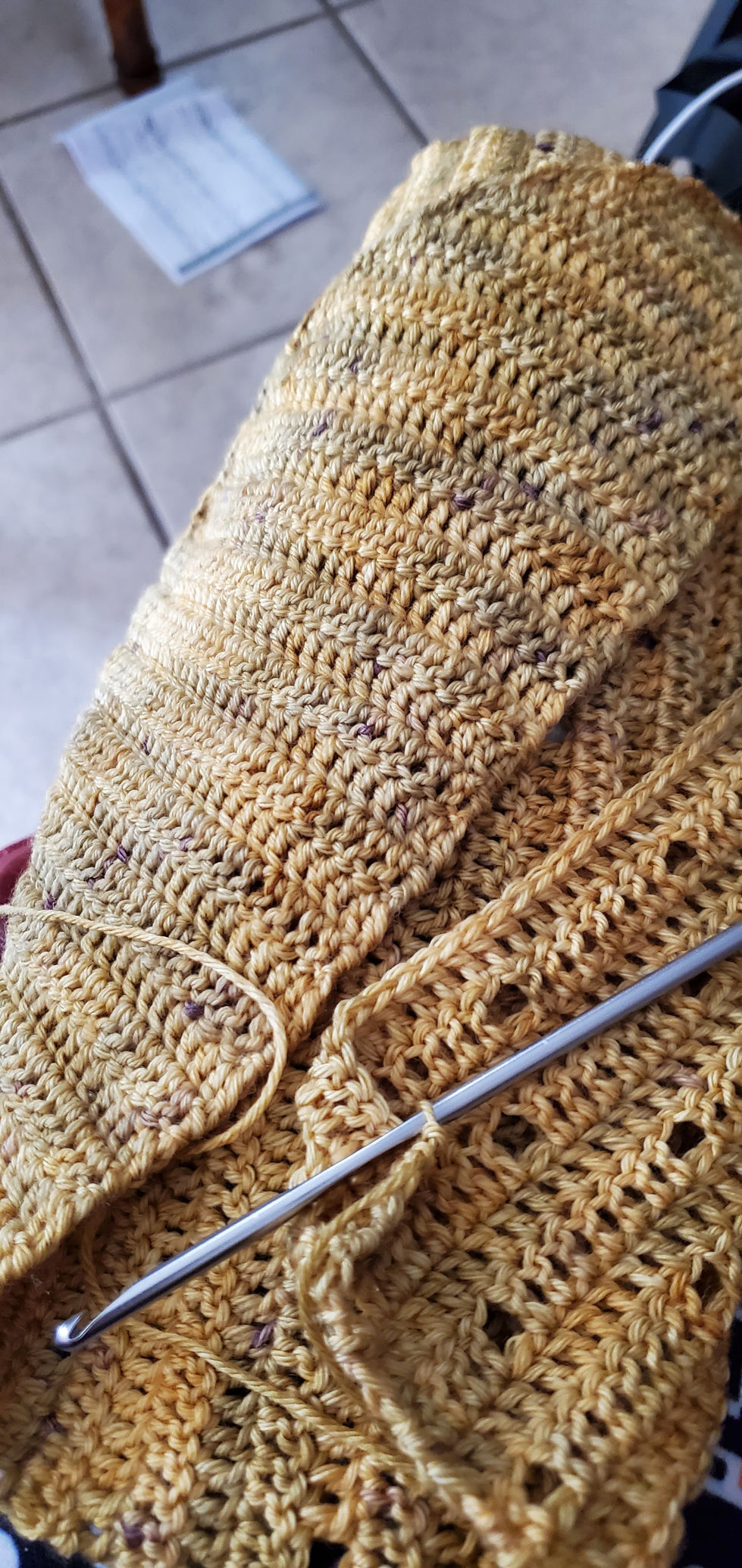 An in-progress yellow crocheted shawl is pictured to show progress.
