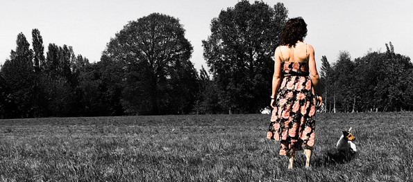 Kerrie and her Jack Russell Terrier, Carrot, looking away over a field.
