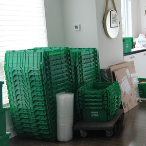 Condo with a mix of Frogbox containers, cardboard boxes, and packing supplies neatly stacked, ready to be packed for the move