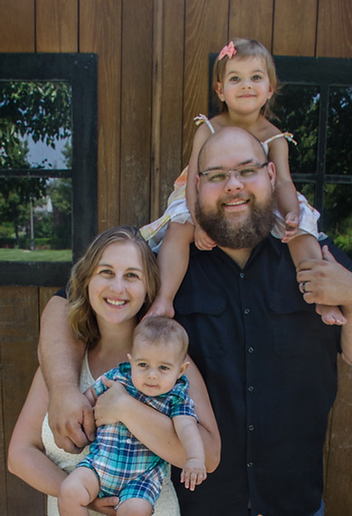 Family smiling in front of barn