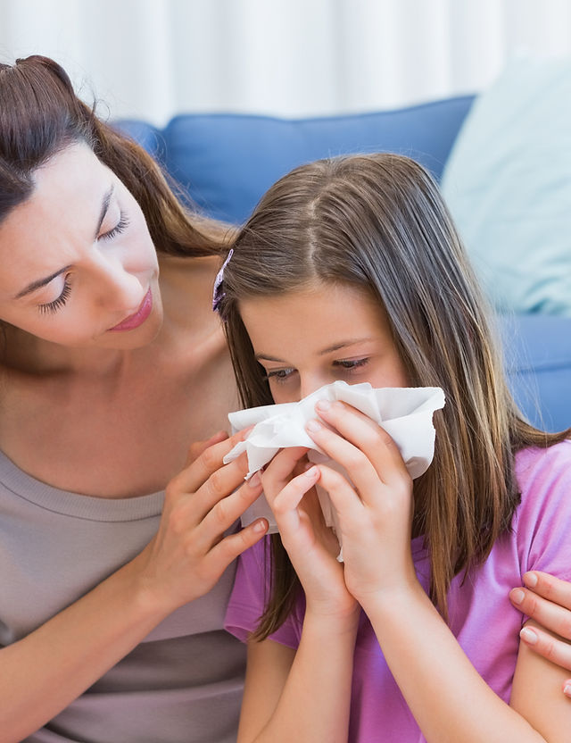 Mother consoling her daughter who is blowing her nose.