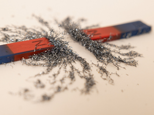 Iron filings between two magnets demonstrate the magnetic fields.