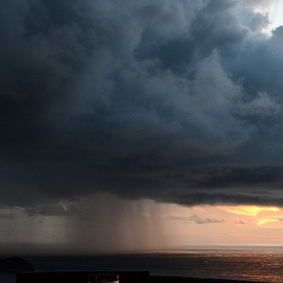 Tropical rainstorm sweeping across the Pacific Ocean at sunset in Costa Rica, capturing the beauty and unpredictability of nature in paradise.