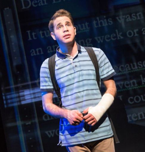 Ben Platt as Evan Hansen in Dear Evan Hansen, wearing a striped polo and arm cast, looking upward in a pool of blue light — the embodiment of anxiety, longing, and misunderstood softness.