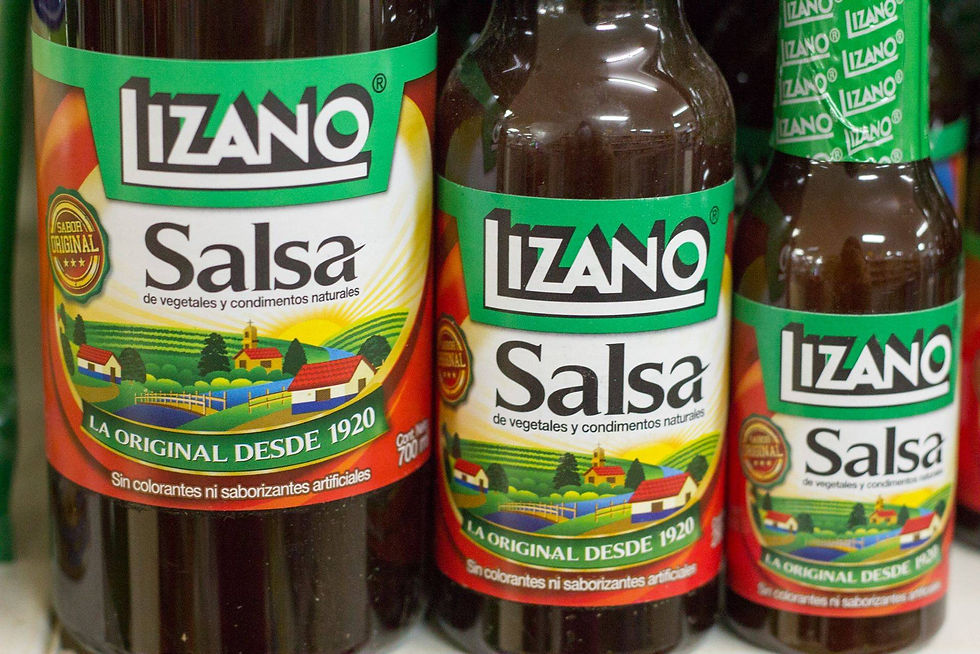 Close-up of Lizano Salsa bottles, Costa Rica’s famous condiment made with vegetables and spices, displayed on a store shelf.