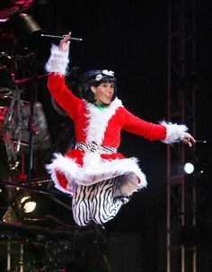 Angel from Rent’s original Broadway cast mid-jump in Santa drag, a joyful and defiant queer musical moment.