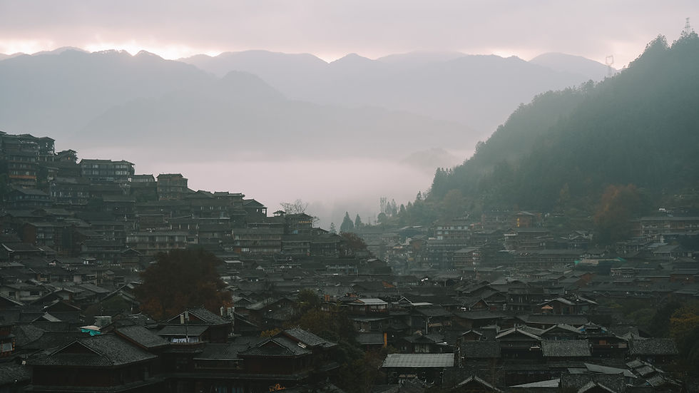 View of traditional wooden buildings and surrounding mountains in Xijiang Qianhu Miao Village, Guizhou, China