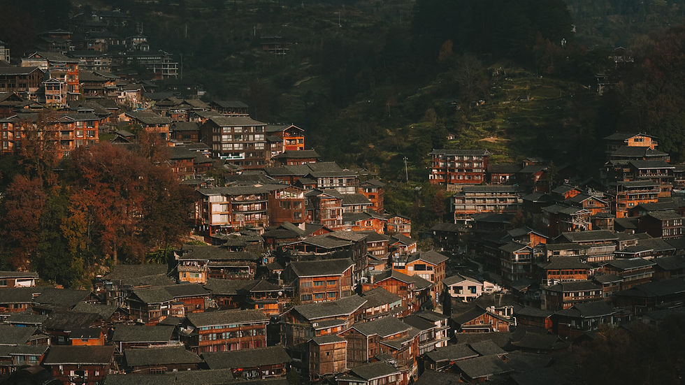 View of traditional wooden buildings and terraced fields in Xijiang Qianhu Miao Village, Guizhou, China