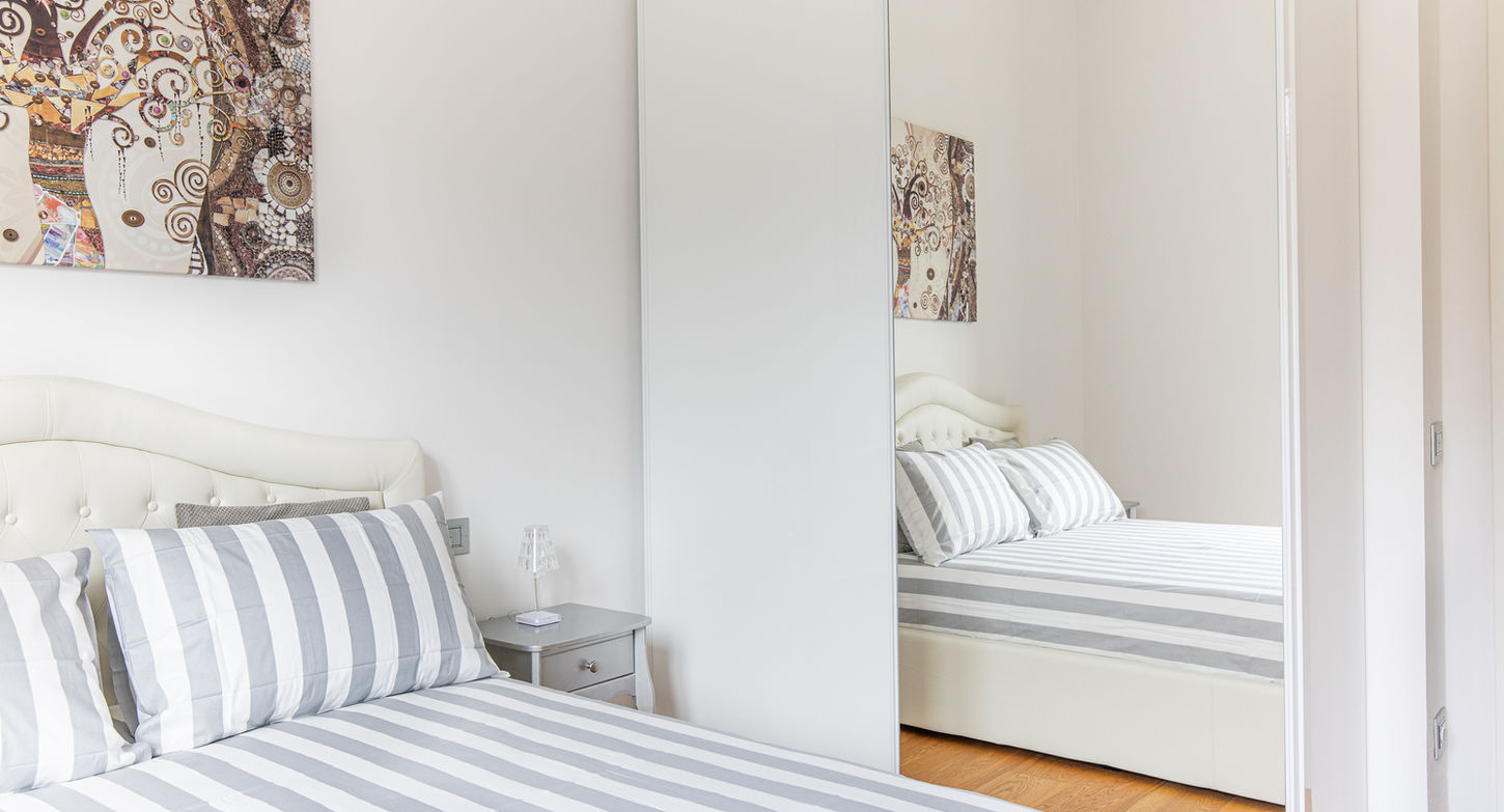Camera da letto elegante con letto a righe grigie