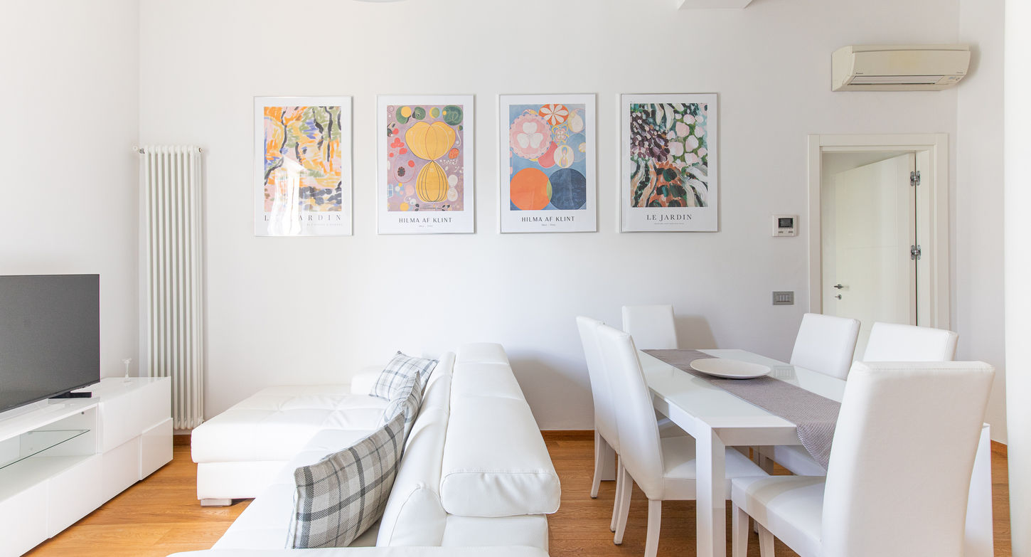 Spazioso soggiorno Elena House: divano, tavolo da pranzo, quadri