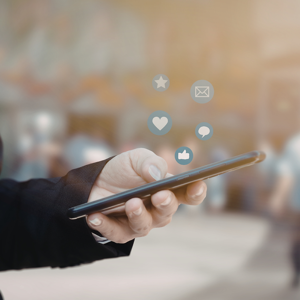 Close-up of a hand holding a smartphone with digital social media notification icons appearing above it.