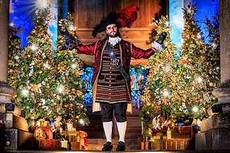 Festive Christmas pantomime performance in the Cotswolds with actors on stage, colourful costumes, and family audience enjoyi