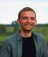 Gründer von Erfolgsufer, Tobias Halstead. Person schaut lächelnd in die Kamera mit schöner Landschaft im Hintergrund