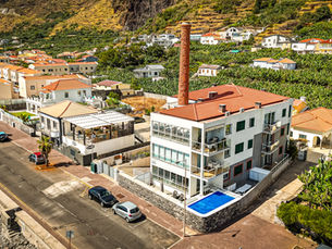 Vista aérea da Conservas Loft no Paul do Mar, com piscina privada e chaminé da antiga fábrica de conservas.