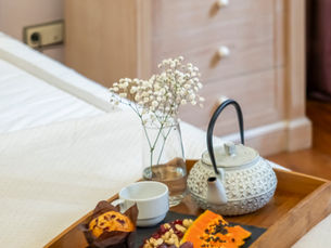Detalhe de cama preparada com lençóis brancos e luz suave, simbolizando a atenção ao conforto antes do check-in.
