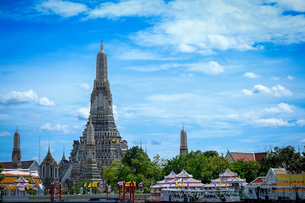 Wat Arun in Bangkok bei Tageslicht, mit detailliertem Zentralprang und dem Chao-Phraya-Fluss im Vordergrund.