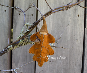 wool felt oak leaf ornament with a wood peg doll gnome with a light brown cap