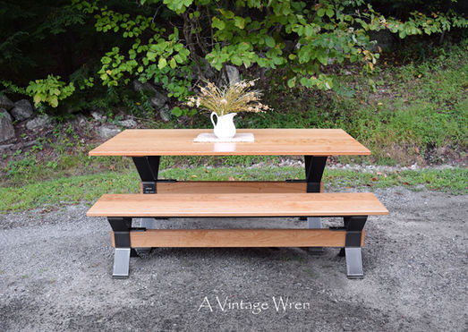 Massachusetts modern industrial trestle dining table and bench set, features a dark metal X style legs with a warm wood top.