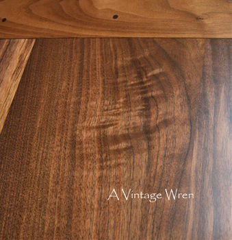 a close up picture of a New Hampshire made farmhouse dining table for 8 to 10. The table top is rich medium to dark brown colored wood made from solid Black Walnut.