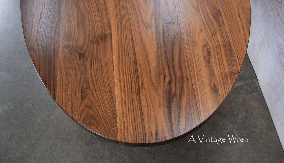 a close up photo of a New Hampshire made oval dining table made of solid black walnut with traditional double pedestal turned trestle base