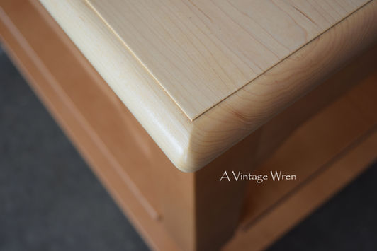 A close picture of a New Hampshire made kitchen island with Maple top with a decorate detail along the edges