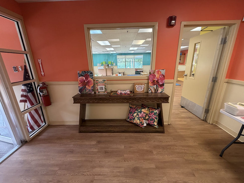 Bright orange lobby at Explorations in Oviedo with a window looking into a classroom
