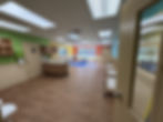 Infant room at Explorations in Oviedo with cribs, changing counter, soft blue rug, and windows