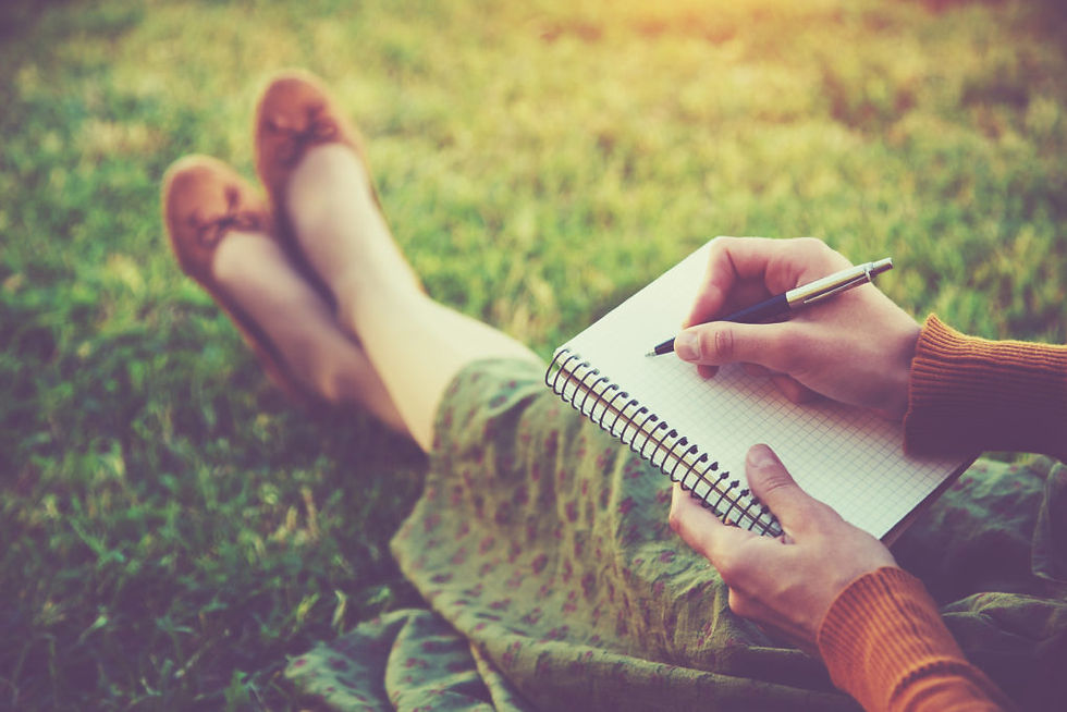 woman sitting on grass journalling her life narrative