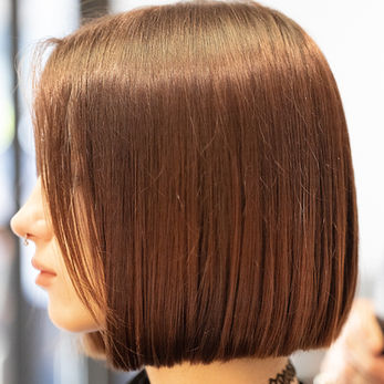 Woman with short, straight brown hair, side view. Hairdresser Colorist