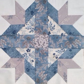 Goose Track block in blue, cream and beige flowery fabric.