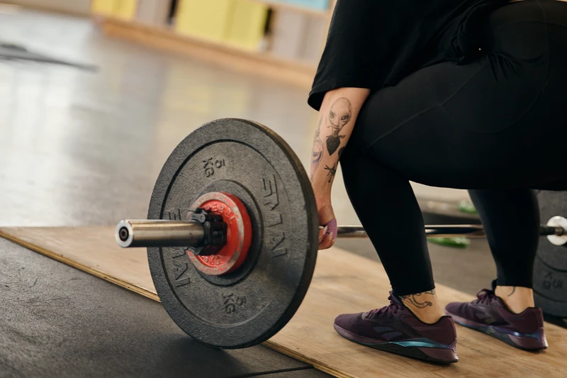weightlifter setting up for a barbell snatch on a weightlifting platform