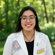 Tiffany Nguyen, L.Ac., Acupuncturist, smiling in white coat and glasses with name badge, outdoors with green background.