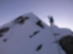 Silhouetted climber on snowy mountain ridge