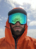 Man in orange jacket with reflective ski goggles