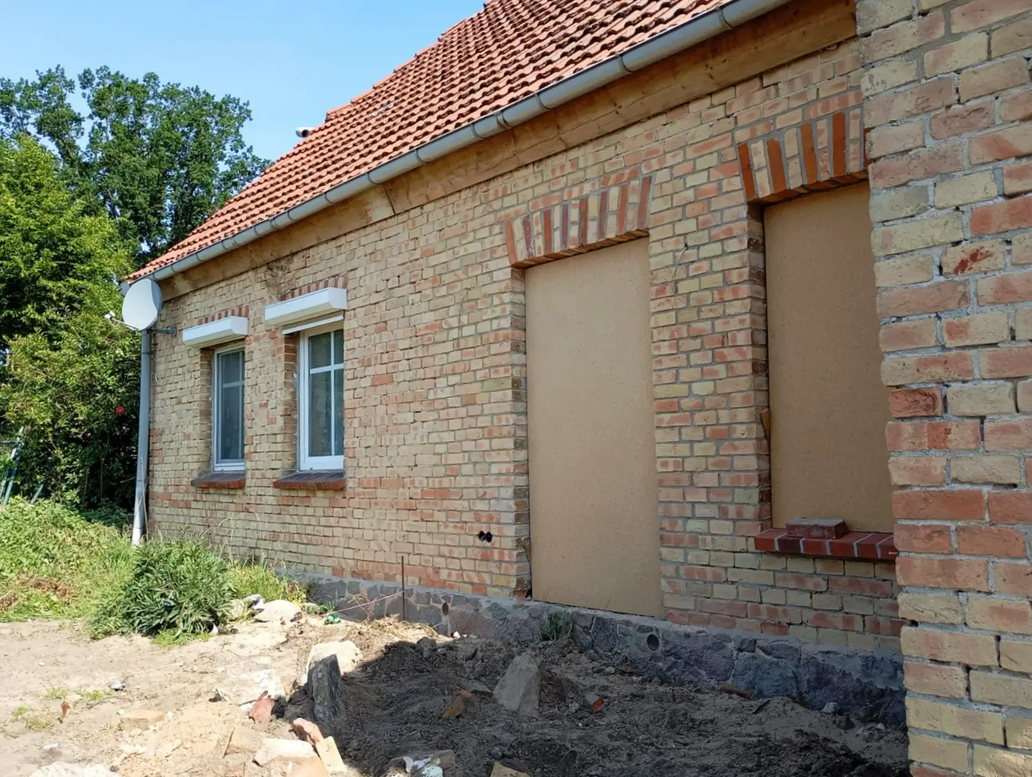 Backsteinfassade ebenmäßig coloriert nach Sandstrahlen, zwei Fensteröffnungen mit Holzschutz verschlossen