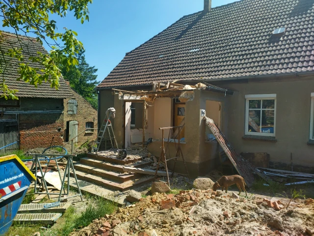 Hauswand mit halb abgerissener Veranda