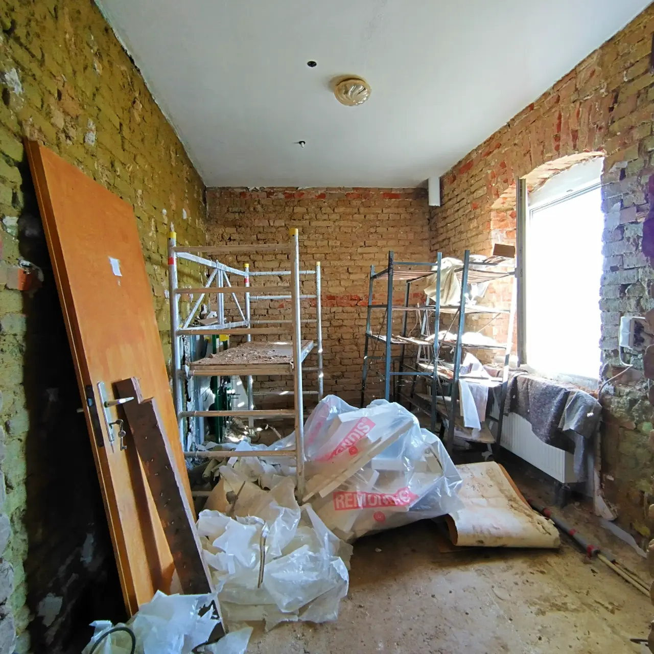 Zimmer im Rohbau mit Wandverkleidung und Fußboden entfernt, Regale und Stauraum