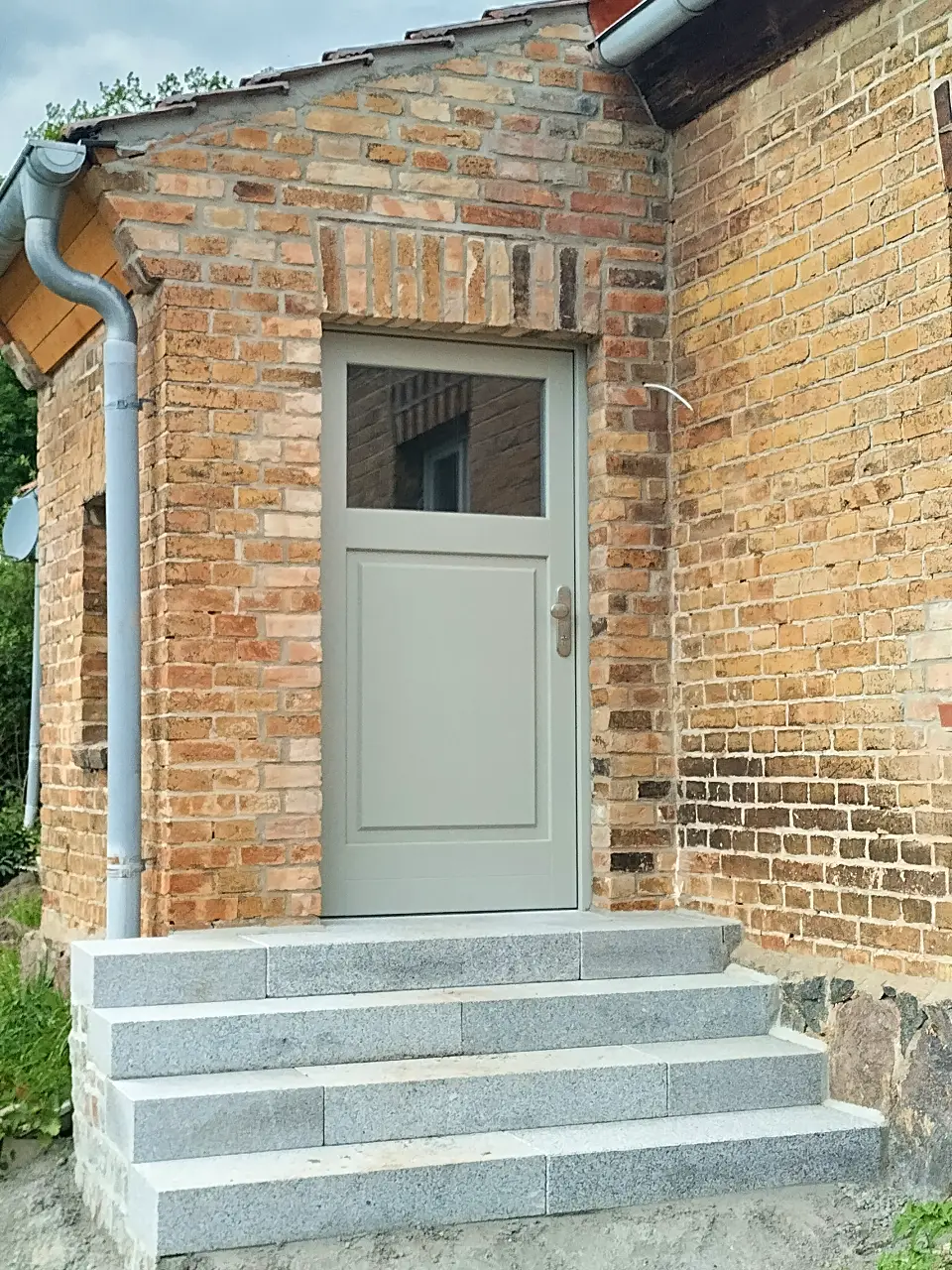 Eingangstür mit Oberlicht in Backsteinwand