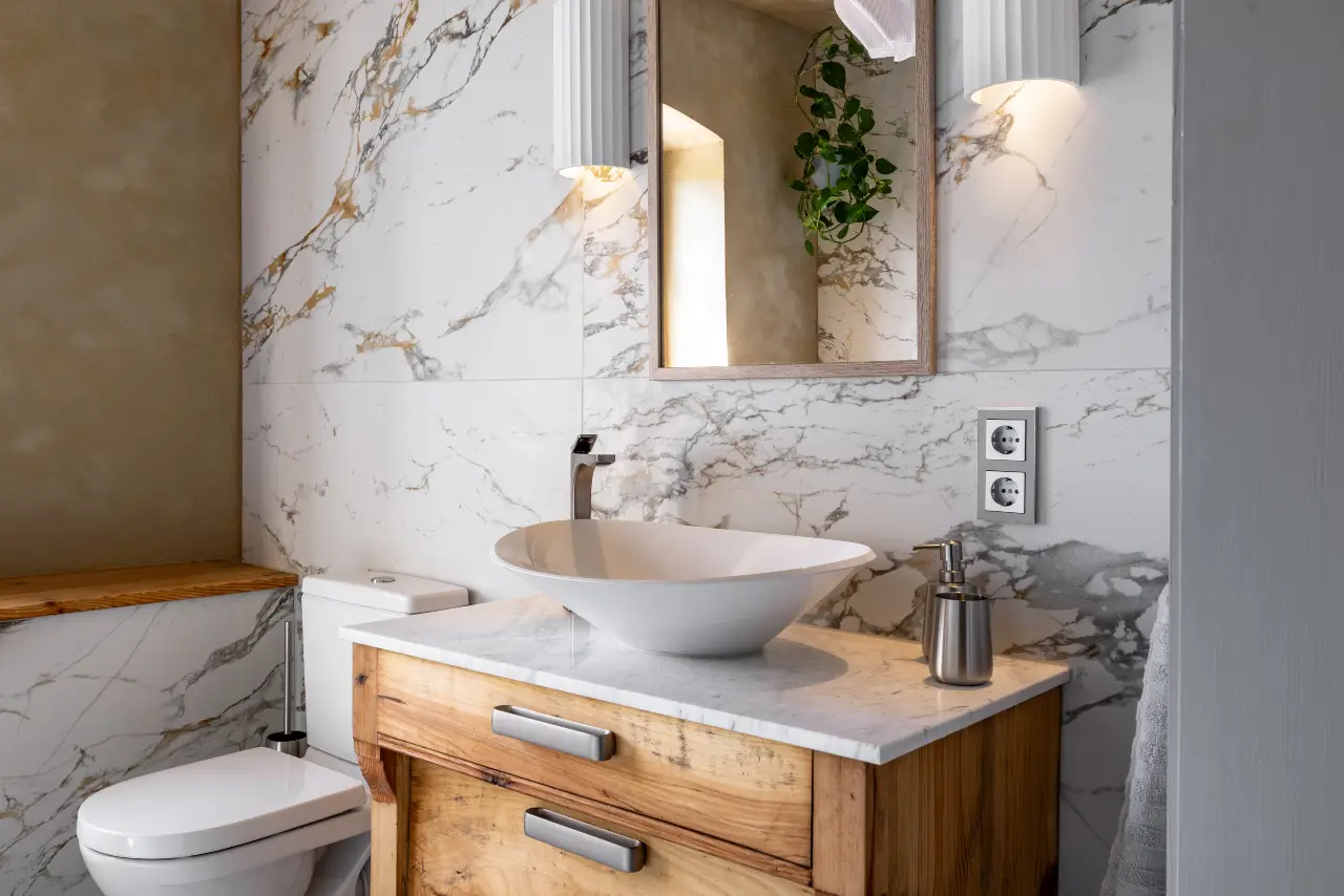Ein modernes Bad mit Marmorfliesen, Holzkommode, Waschbecken, Toilette.