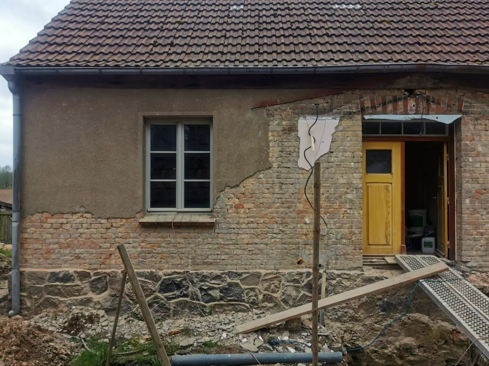 Ziegelfassade mit halb entferntem Betonputz
