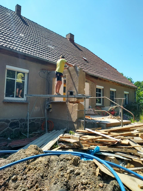 Mann auf Arbeitsbühne reißt Mauer ein
