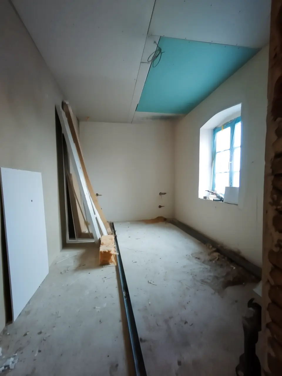 Ein Zimmer im Renovierungszustand, neu abgehängte Trockenbaudecke.
