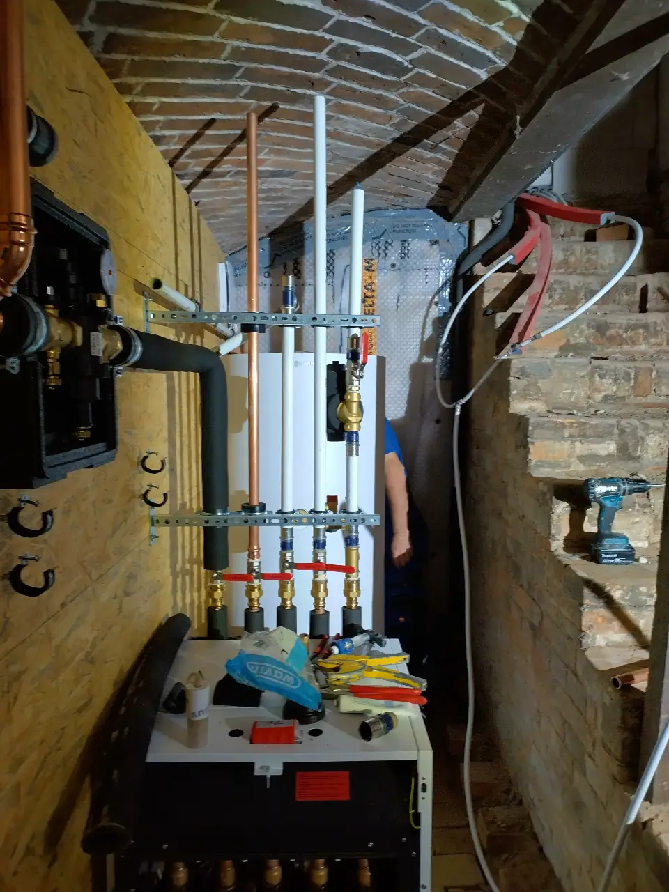Eine Wärmepumpenanlage wird in einem alten Gewölbekeller gebaut