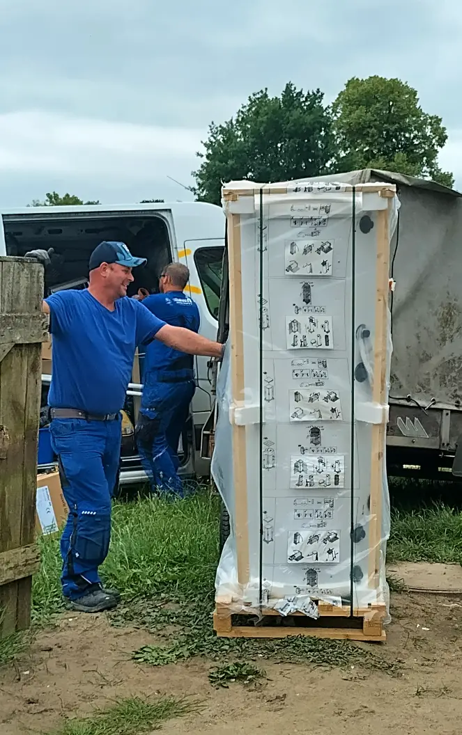 Ein Techniker steht neben einem Warmwasserspeicher