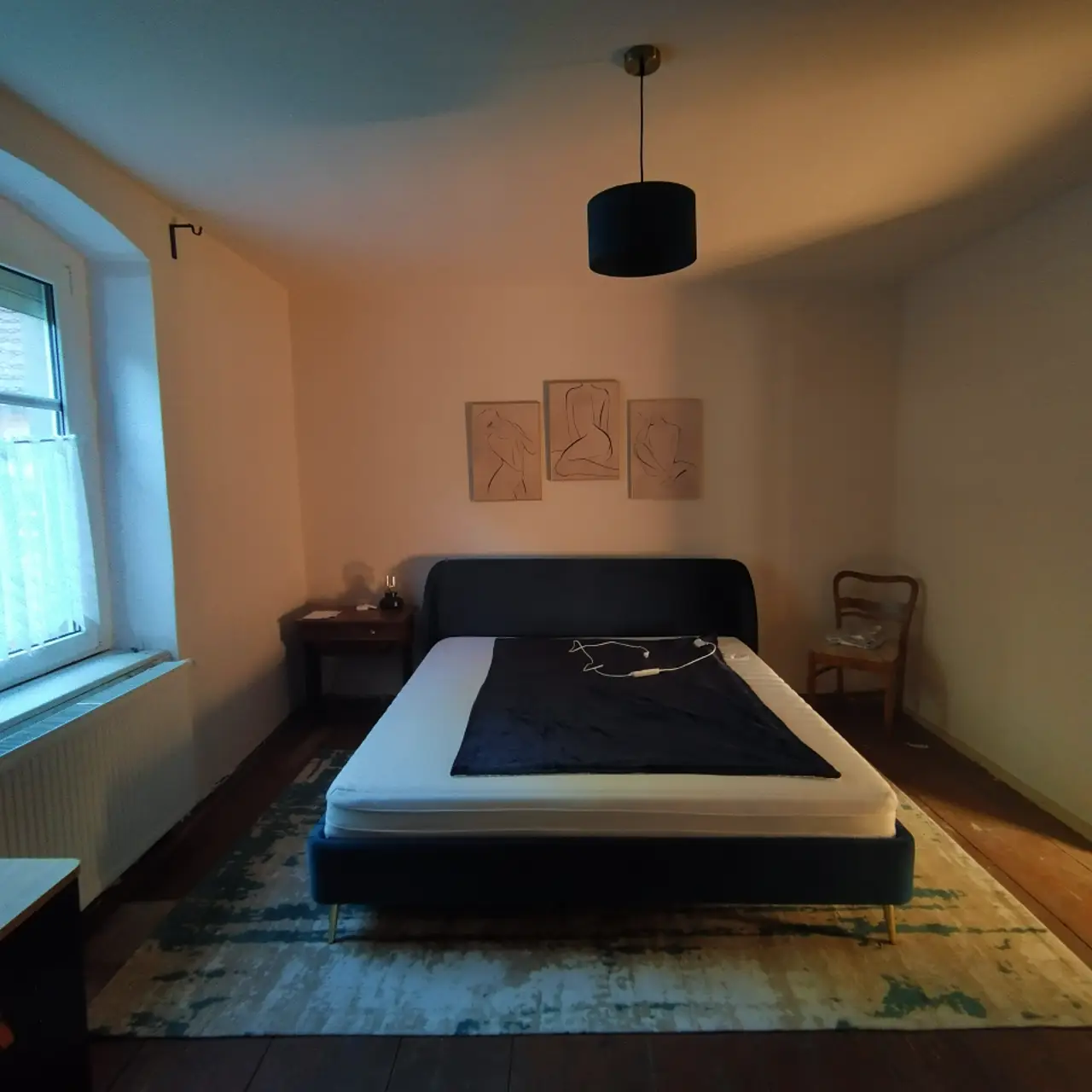 Schlafzimmer mit Doppelbett und Bildern an der Wand